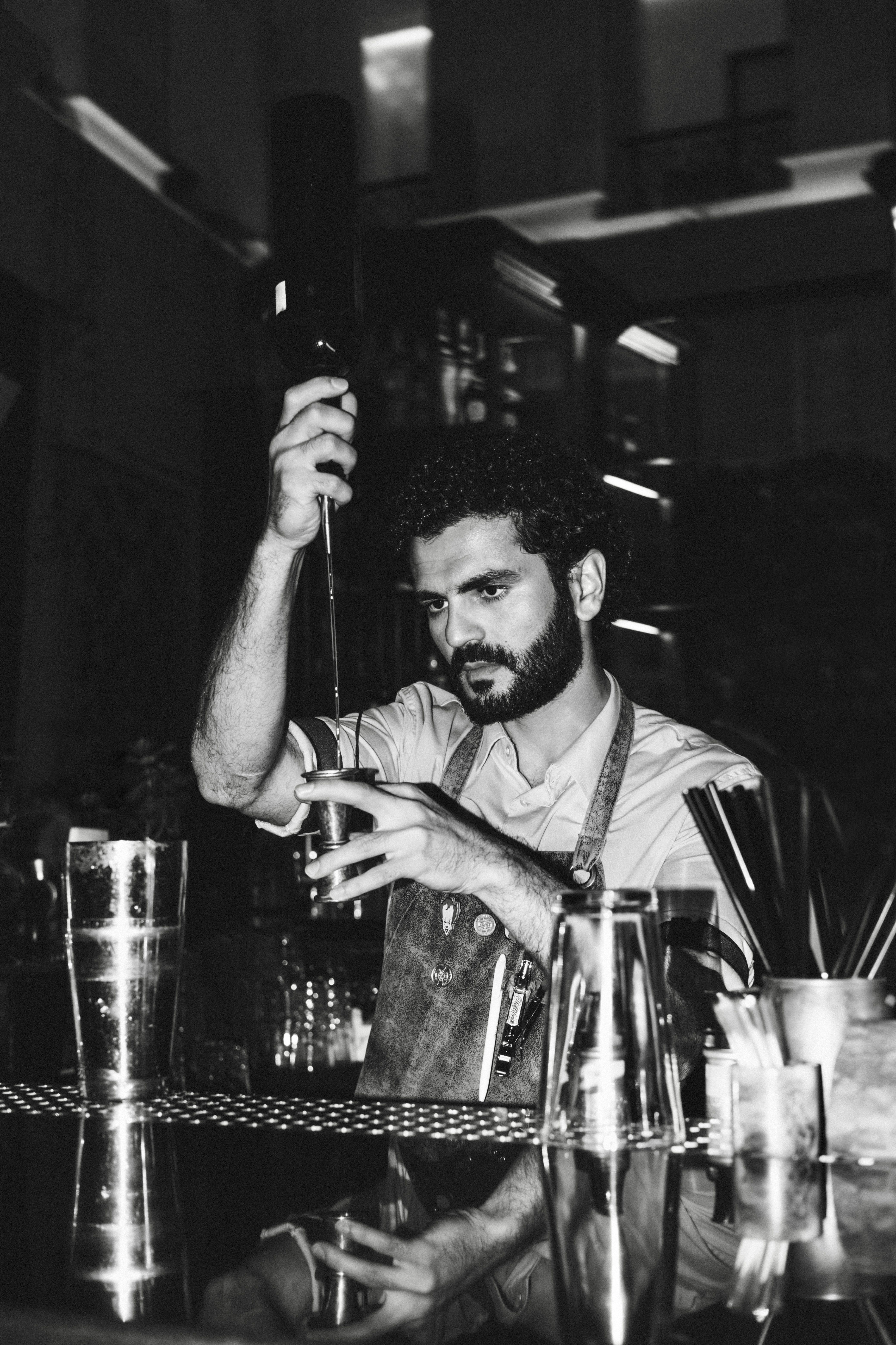 A professional bartender expertly mixes a cocktail in a stylish bar setting.