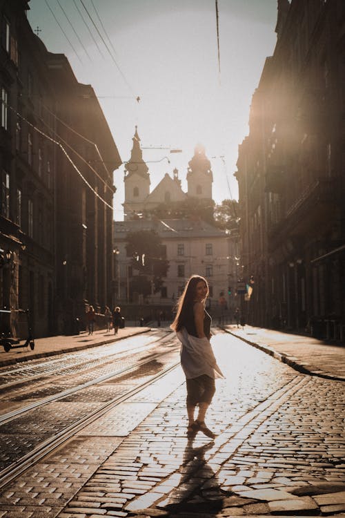 Woman Posing on Street with Church behind at Sunset