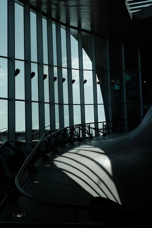 Free Sophisticated urban interior with dramatic shadows cast through large windows for a modern ambiance. Stock Photo