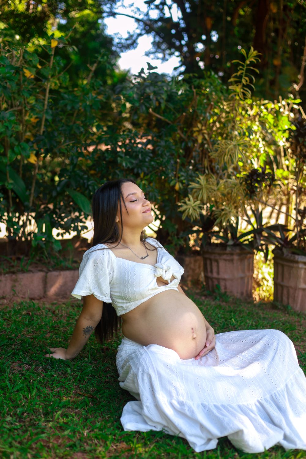 Maternity portrait in a sunlit garden