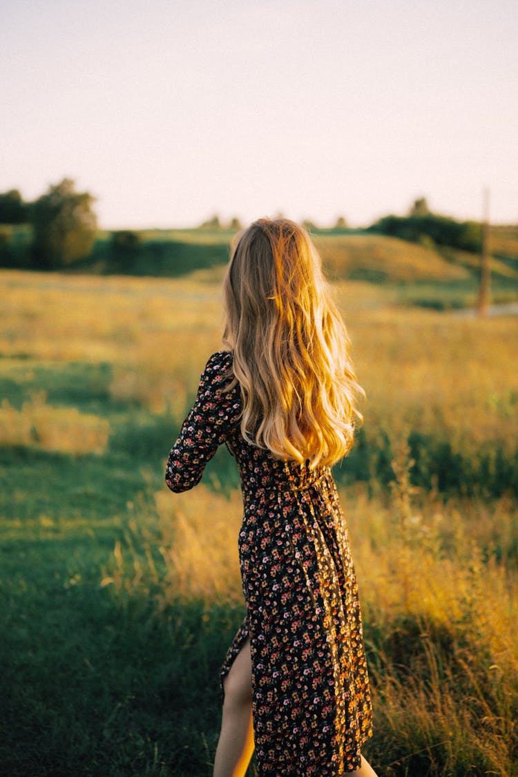 Woman With Long Hair And A Dress Walking In A Field