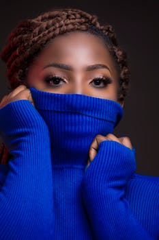 一位身穿鲜艳蓝色高领毛衣的女子肖像特写，突出了她的眼睛