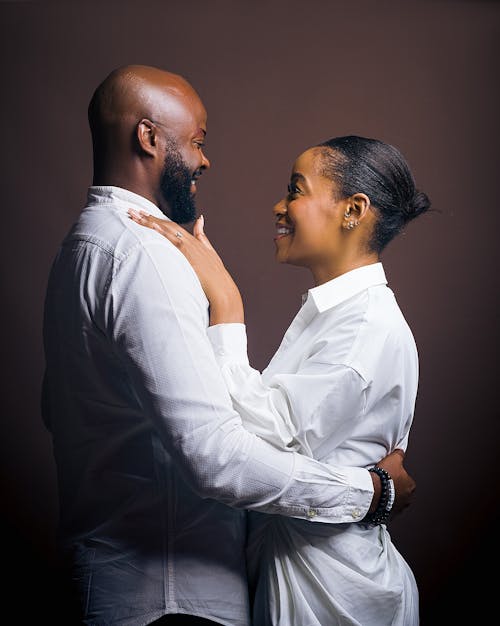 Smiling Couple in White Shirts Hugging
