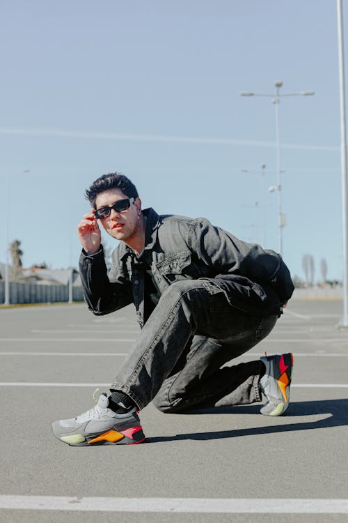 Model in Denim Jacket Jeans and Sports Shoes Posing in the Parking Lot