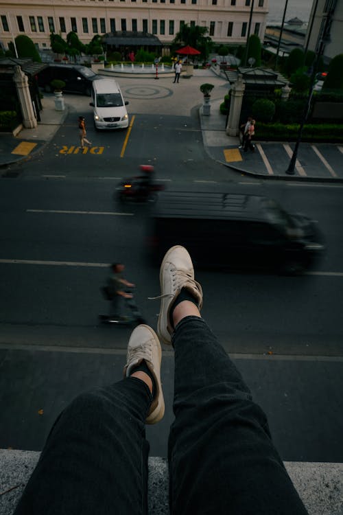 Legs of Person Sitting over Street