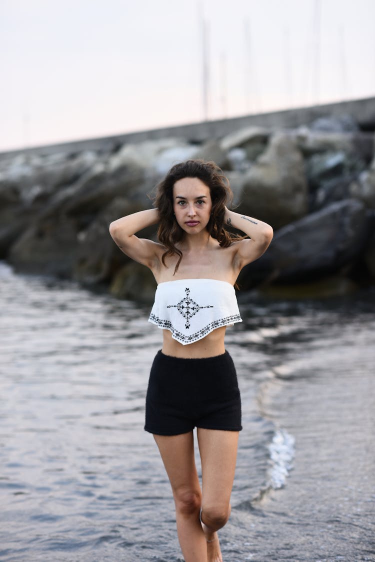 Woman In A Top And Shorts Walking On The Beach