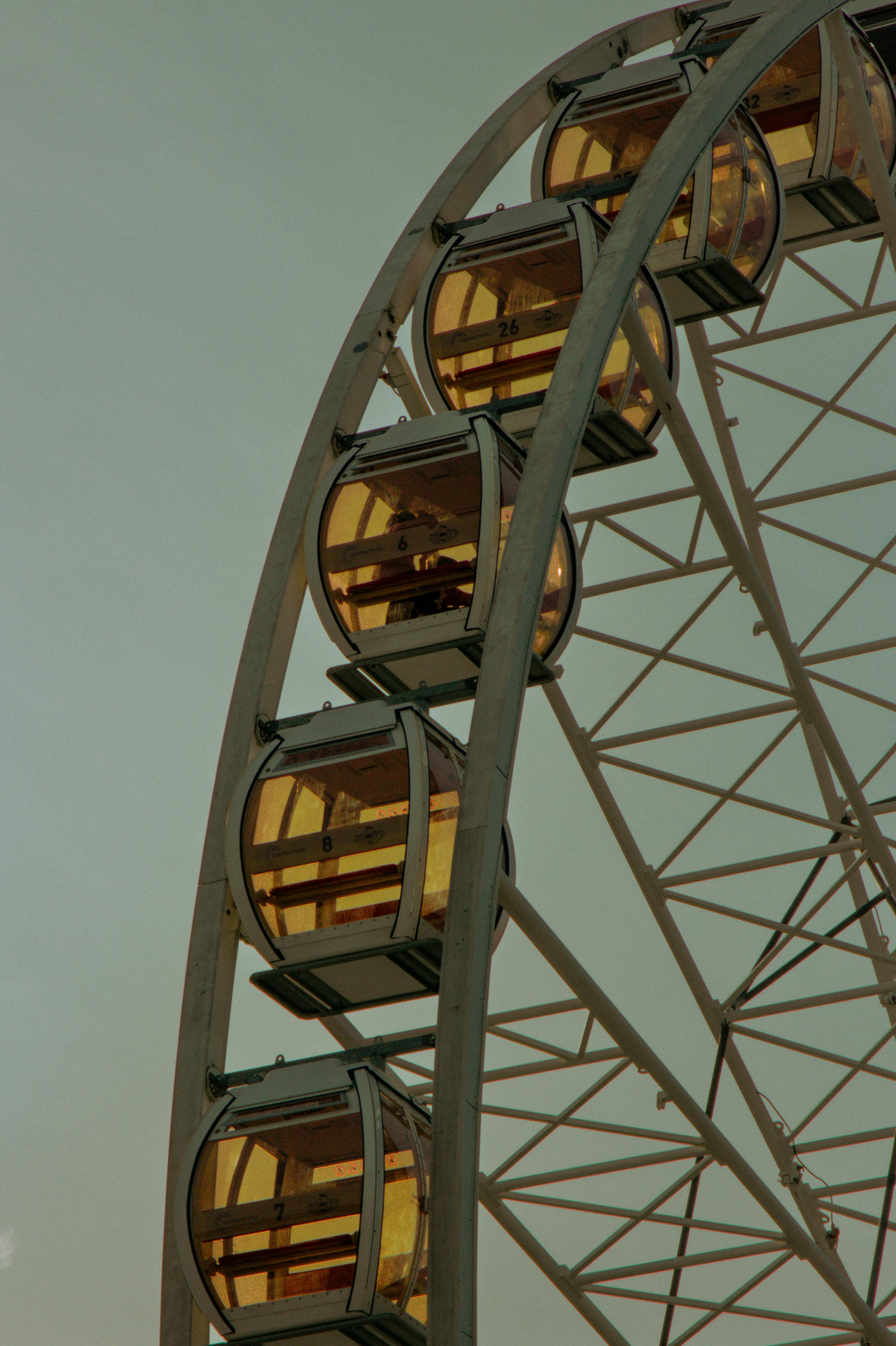 Close-up view of a Ferris wheel in Kraków, Poland against a dusky sky, capturing a moment of calm.