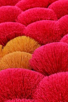 Vibrant display of red and orange incense sticks, showcasing cultural craftsmanship in Hanoi.