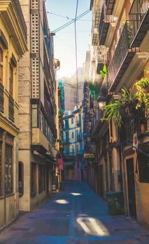 Vibrant narrow street with traditional buildings in Valencia, Spain.