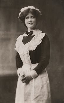 Classic black and white photo of a maid in retro uniform showcasing vintage fashion.