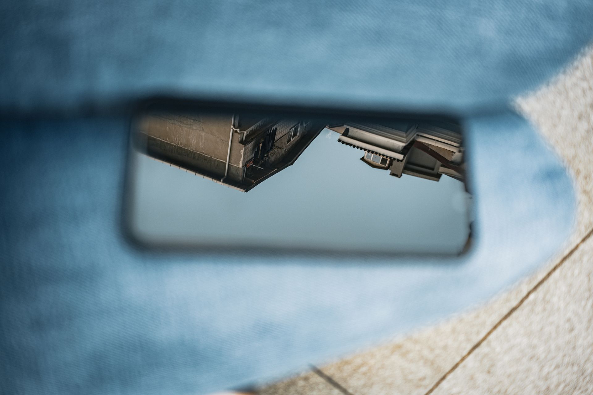 Reflection of urban buildings on a smartphone screen being held with denim background.