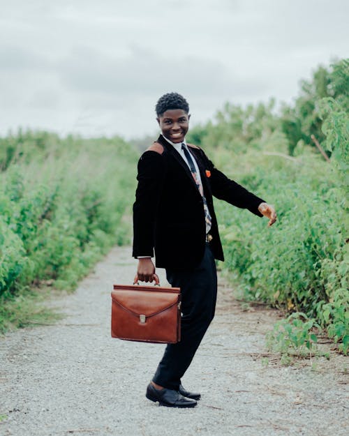 Smiling Man in Black Suit and with Suitcase