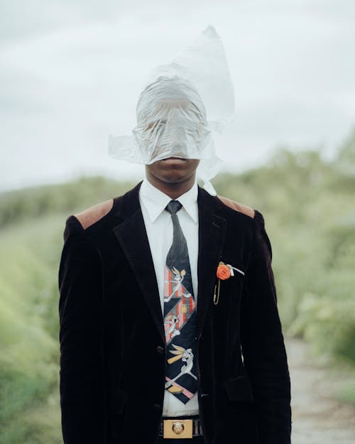 A Man in a Suit Wearing a Plastic Bag on His Head 