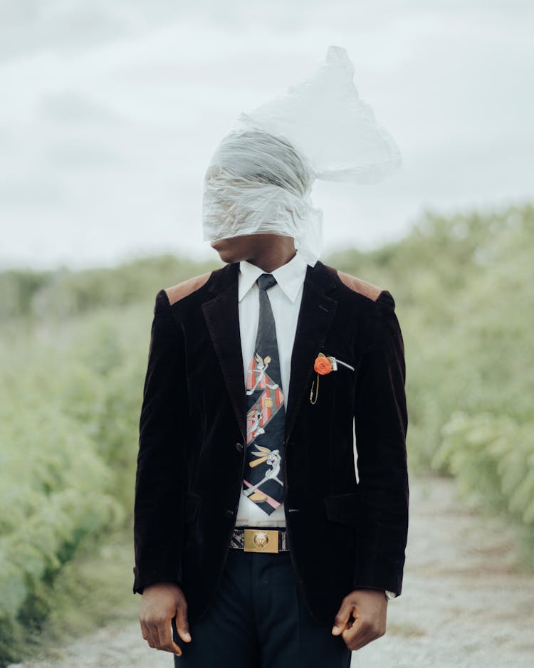 Man In Black Suit And Necktie Wearing Plastic Bag On Head