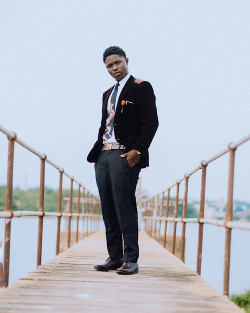 A Young Elegant Man Standing on a Wooden Pier 