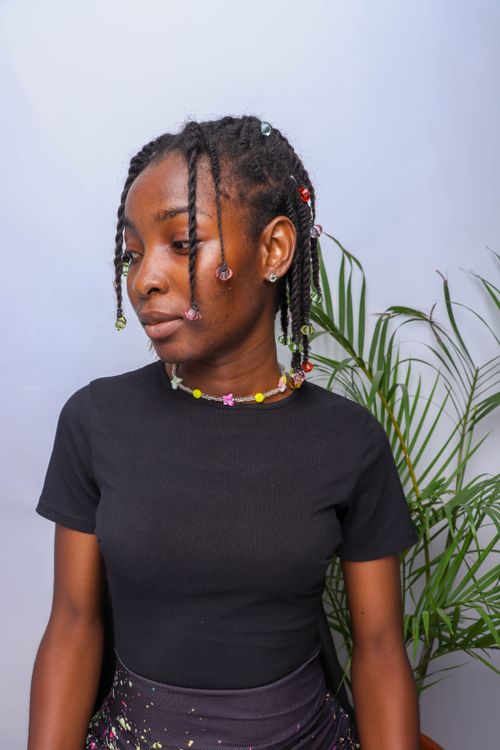 Free Portrait of a stylish young woman with braided hair and colorful beads, showcasing fashion in Lagos, Nigeria. Stock Photo