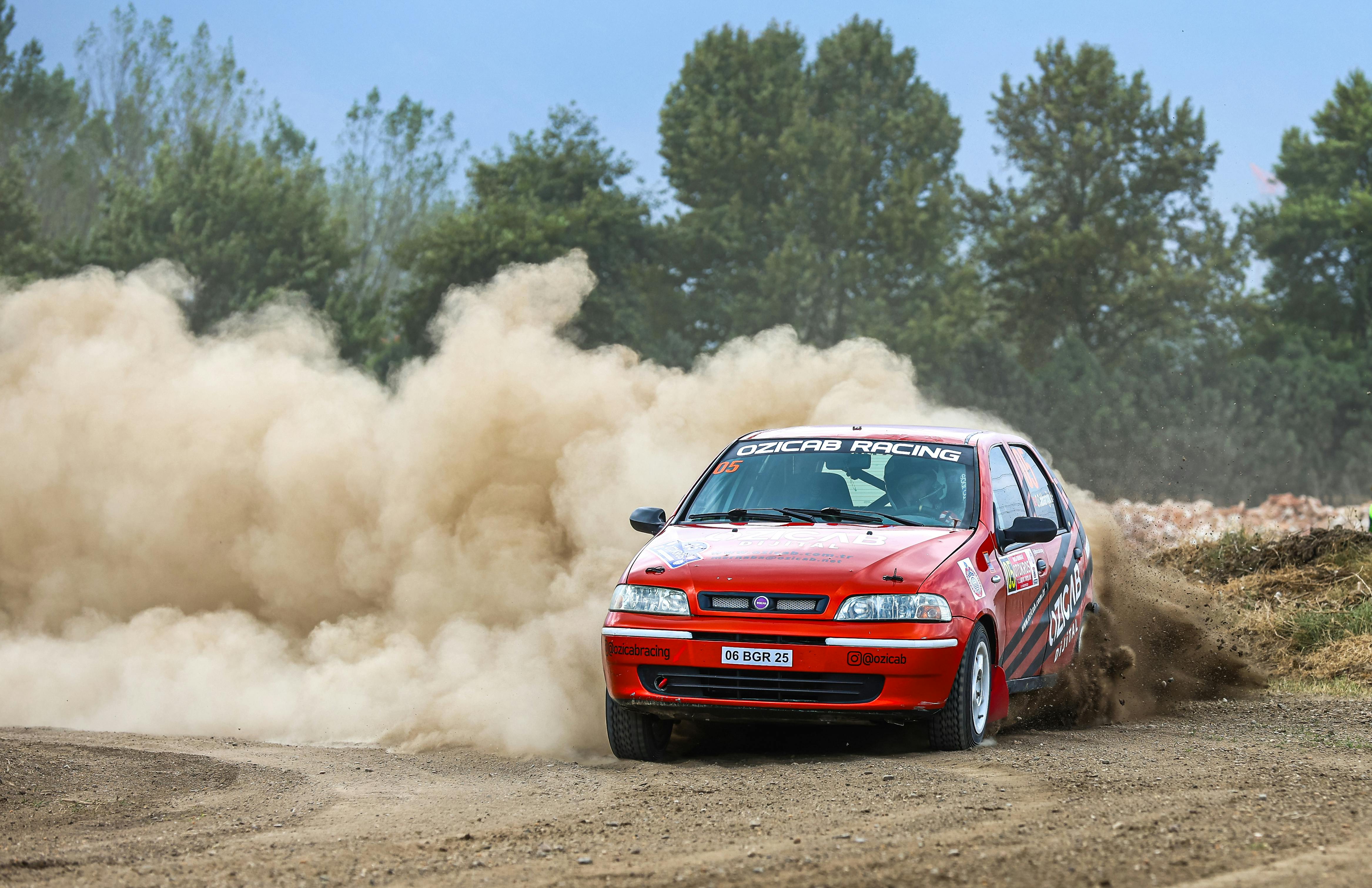 A car driving through a dirt field with smoke coming out of it · Free Stock Photo
