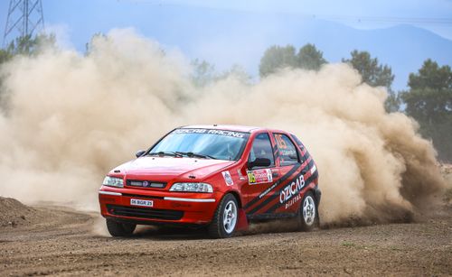 Free Fiat rally car kicking up dust on an outdoor track, capturing the thrill of speed and action. Stock Photo