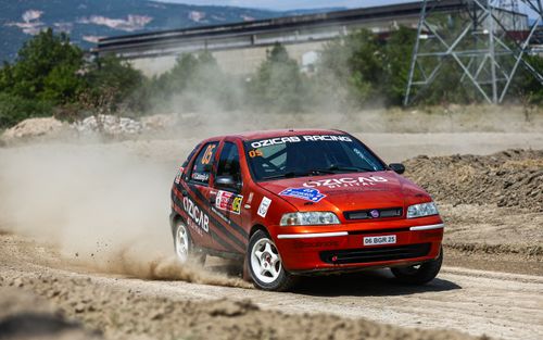 Free A Fiat Palio fiercely competes in a dusty rallycross event, capturing the thrill of motorsport. Stock Photo