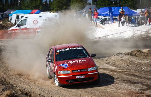 Free A Fiat racing car drifts on a dirt track amidst spectators at a rallycross event. Stock Photo