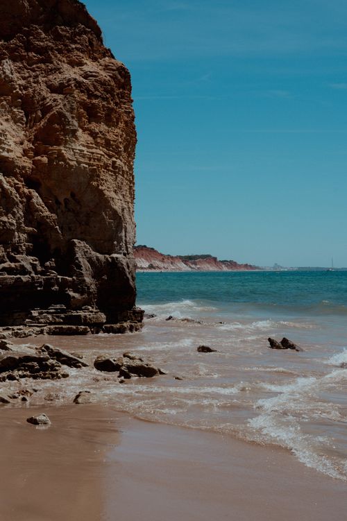 Free Breathtaking view of rocky cliffs and the turquoise sea on a sunny day at the beach. Stock Photo