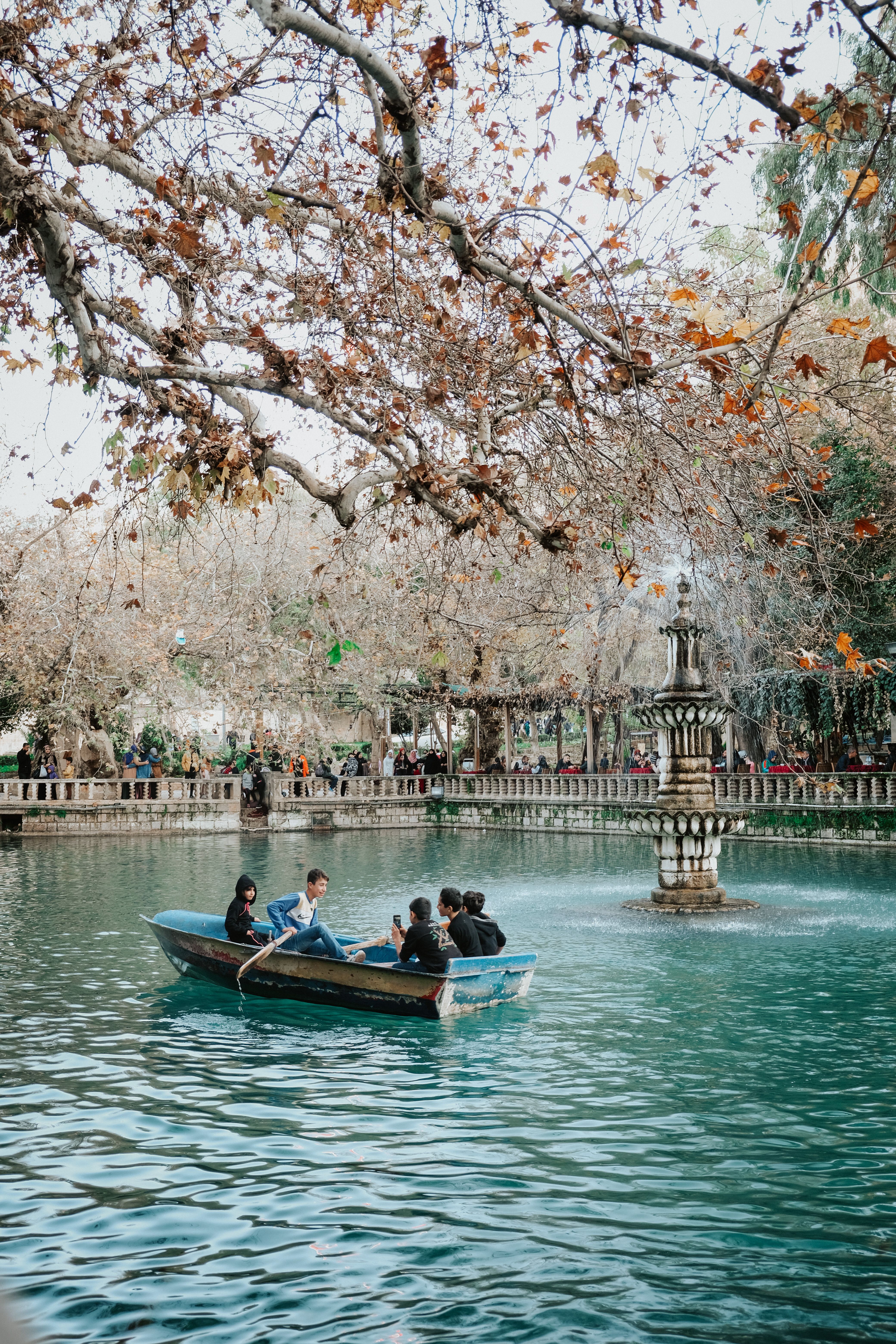 Boating on Ayn Zeliha Lake with tourists surrounded by fall foliage.