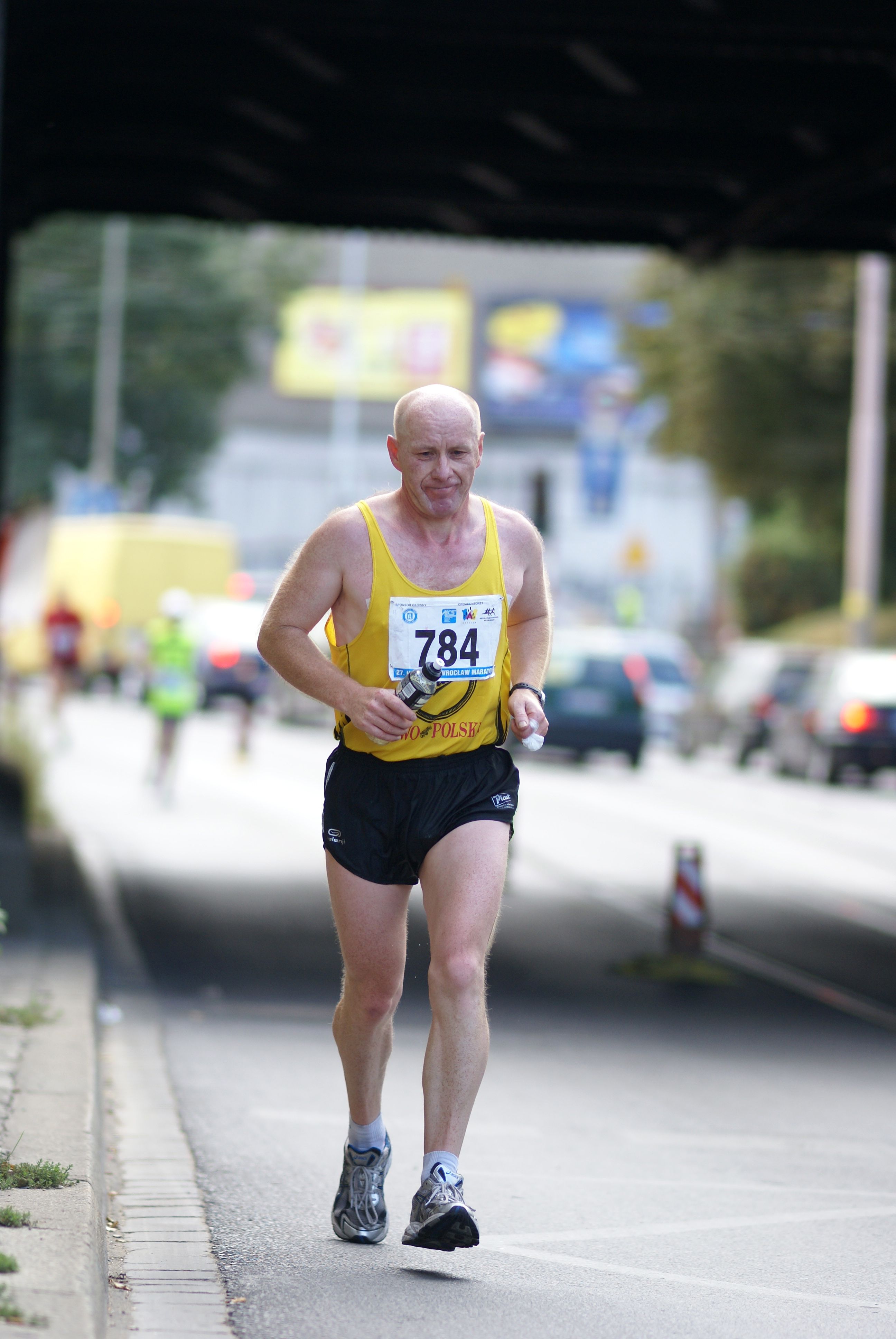 Senior male runner competing in a city marathon, showcasing endurance and determination.