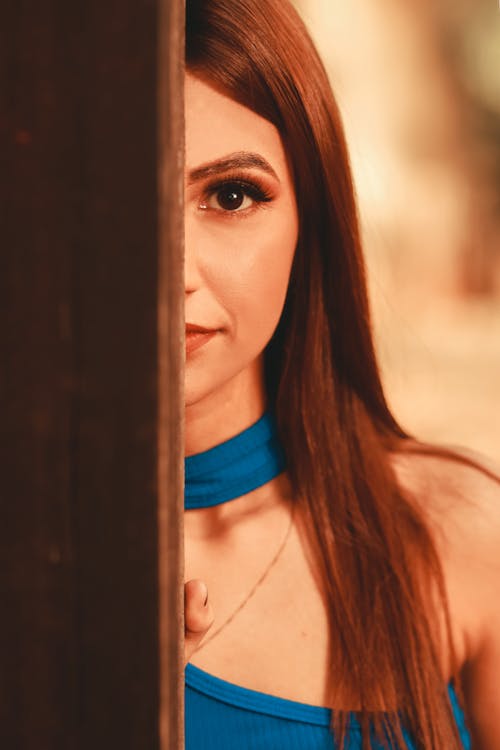 Woman Standing Behind a Wooden Door 