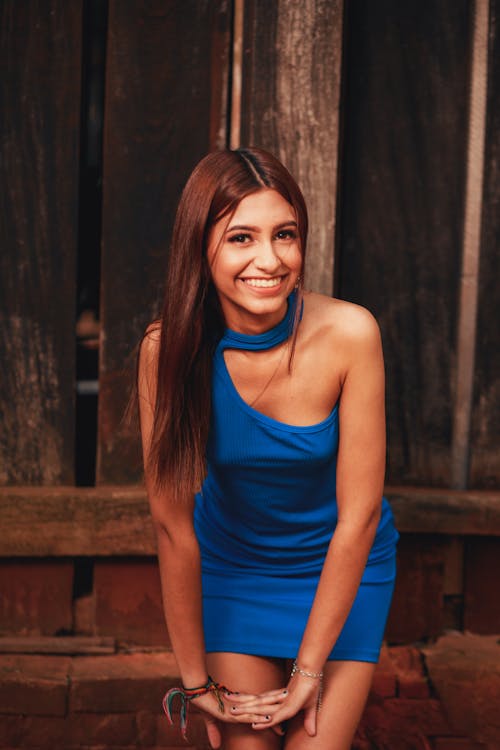 Young Woman in a Blue Dress Standing and Smiling 