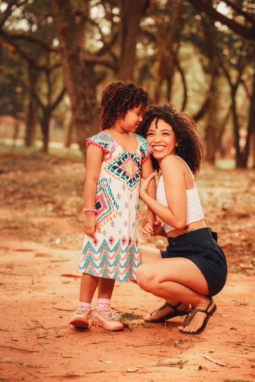 Free A mother and daughter share a joyful moment outdoors in a sunlit park. Stock Photo