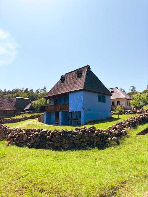 A house with a blue roof and stone walls