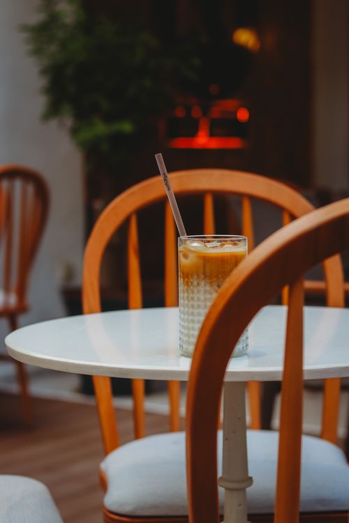 Free A cozy cafe atmosphere in Ankara with an iced coffee on a wooden chair background. Stock Photo