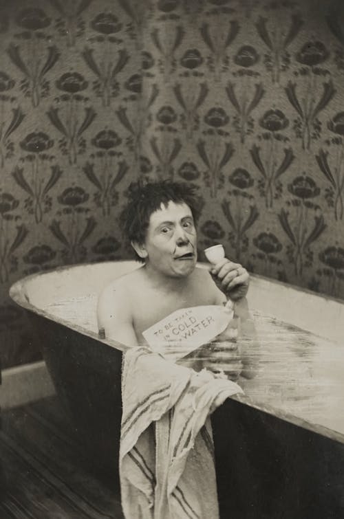 Black and White Photo of a Woman in a Bathtub 