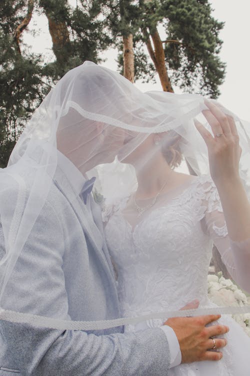 Newlyweds Kissing under Veil