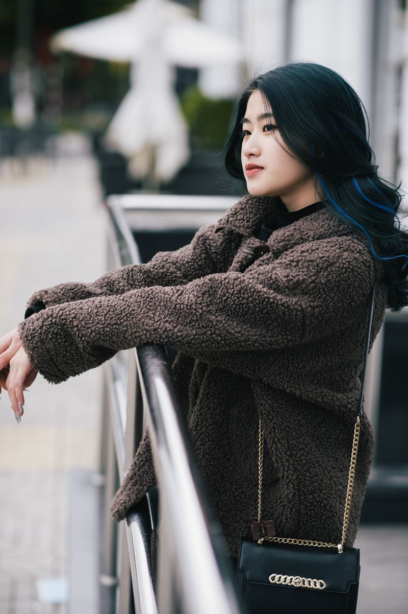 Woman in teddy jacket leaning on a railing