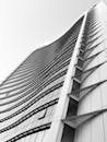从低角度拍摄的现代摩天大楼，以其引人注目的黑白照片和独特的弯曲门面而显得格外突出