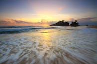 在平静的海滩上，日出伴随着温柔的波浪，令人叹为观止