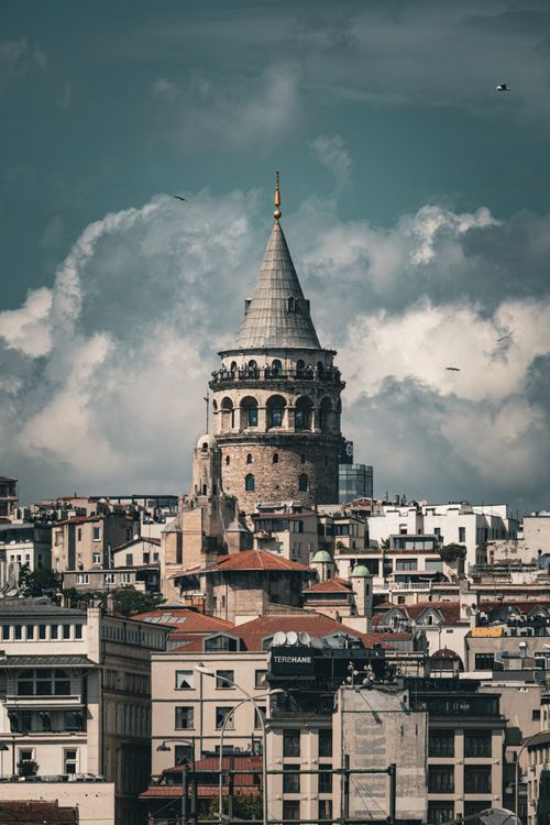 Free Vertical shot of Galata Tower amidst Istanbul's picturesque skyline under dramatic clouds. Stock Photo