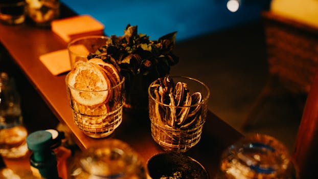 A stylish bar counter with dried citrus slices and herbs under warm lighting.