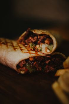 Close-up of a tasty grilled burrito with meat and vegetables, perfect for lunch.