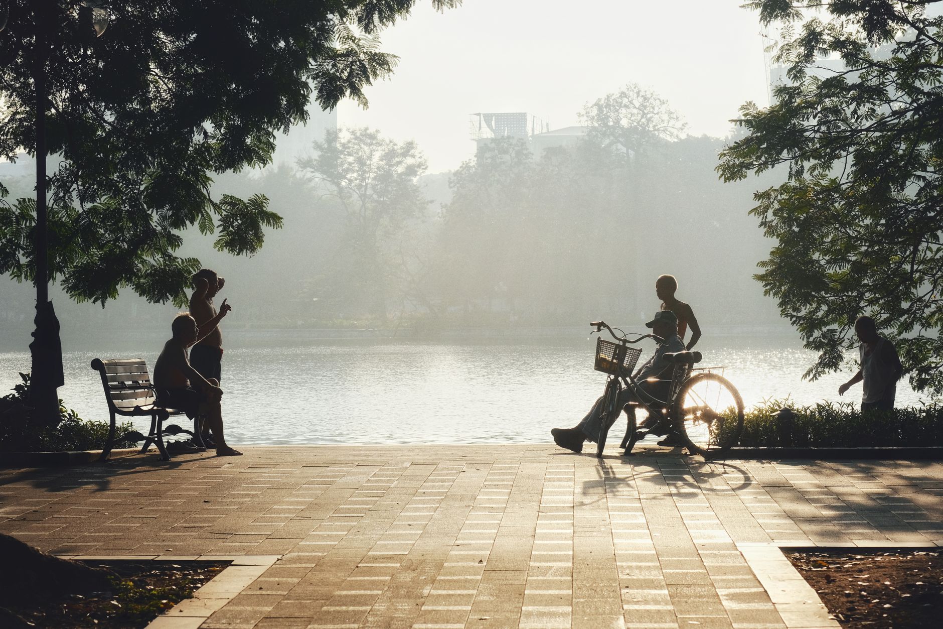 Silhouettes enjoy a tranquil morning at Hoàn Kiếm Lake in Hanoi, Vietnam.