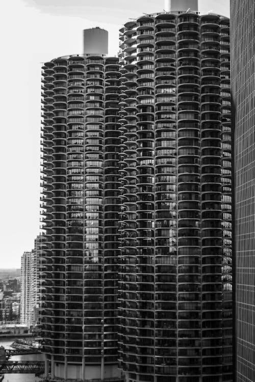 Facade of tall building with glass mirrored windows located near river against cloudless sky