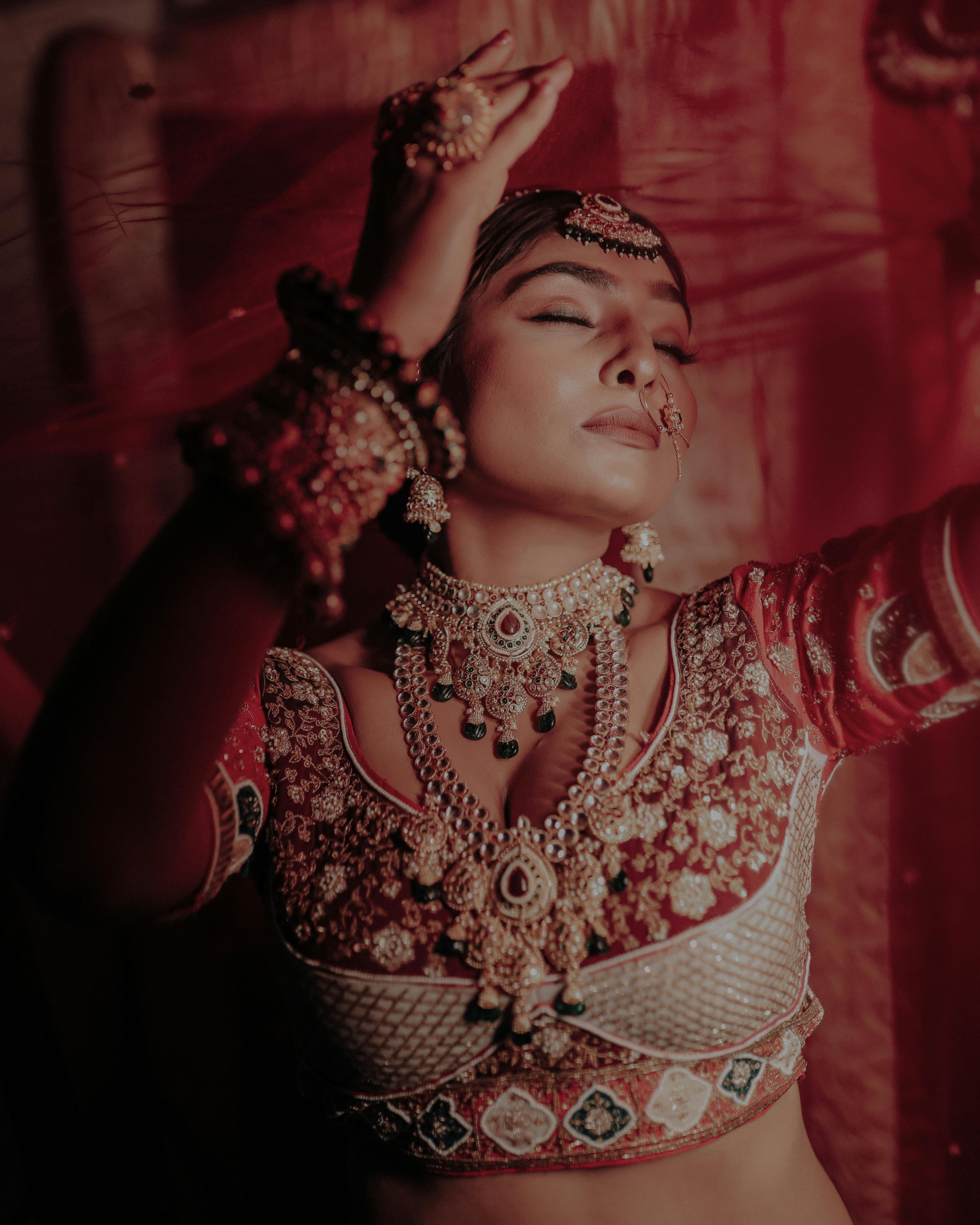 Close-up portrait of a stunning Indian bride in traditional bridal attire and jewelry.