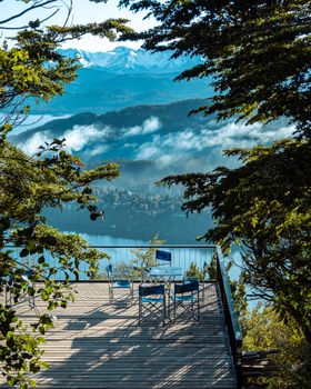A serene terrace with chairs overlooking a beautiful mountain lake in San Carlos de Bariloche, Argentina.