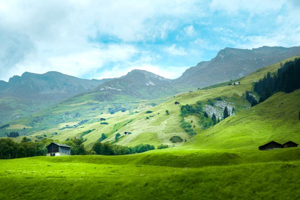 Green alpine slopes under low cloud — photo by Jakub Zerdzicki on Pexels