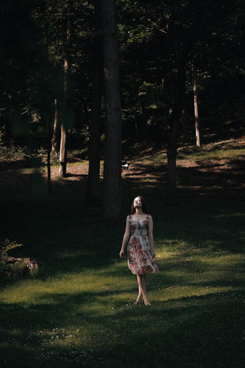 Woman in Floral Sundress Standing in Meadow