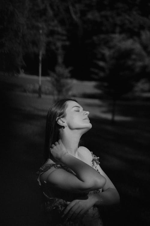 Woman in Floral Sundress with Closed Eyes Fixing Hair