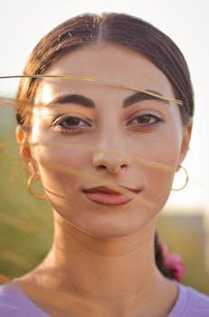 Close-up portrait of a woman with natural makeup in soft sunlight.