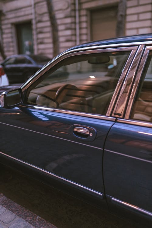 A Vintage Car Parked on the Side of a Street in City 