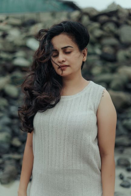 Serene outdoor portrait of a woman with long hair and closed eyes, exuding calmness.